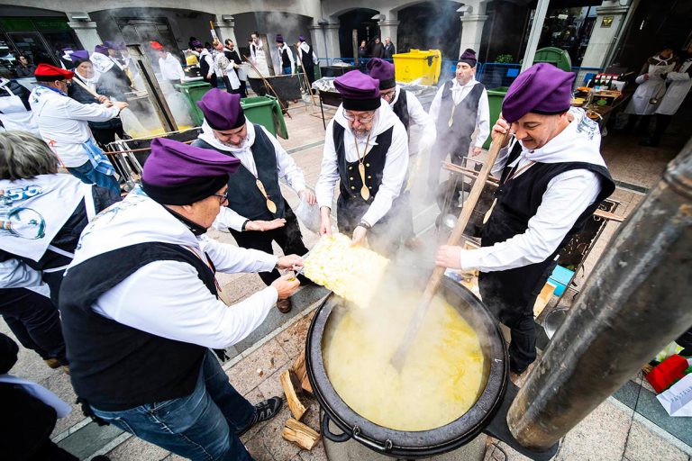 Grup d'homes preparant l'escudella popular a Andorra, tradicions centre comercial illa Carlemany